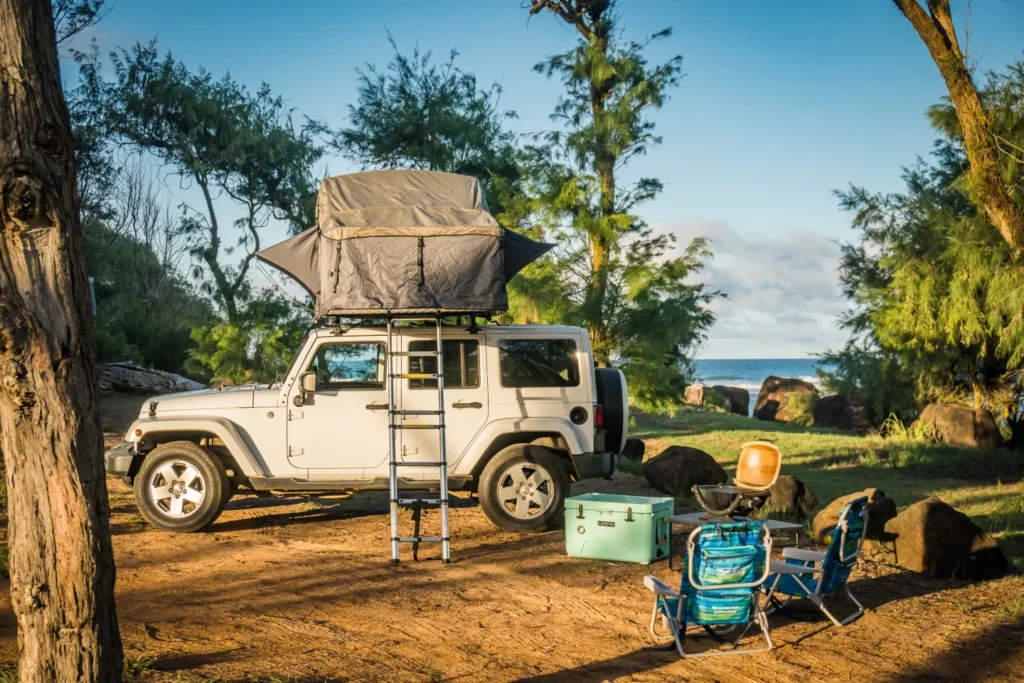 White Wrangler Kauai camper Jeep in Lihue, Hawaii. This 18-foot camper sleeps 2 guests, accommodates up to 4 passengers, has a 4.3-star rating from 23 reviews, offers unlimited mileage, and is not pet-friendly.