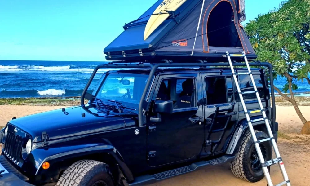 Jeep Wrangler Sahara camper in Kahului, Hawaii, upgraded with a rooftop tent. This 16-foot camper sleeps 2 guests with a full-size bed, accommodates up to 5 passengers, has a 5.0-star rating from 107 trips, offers unlimited mileage, does not have a generator, and is not pet-friendly.