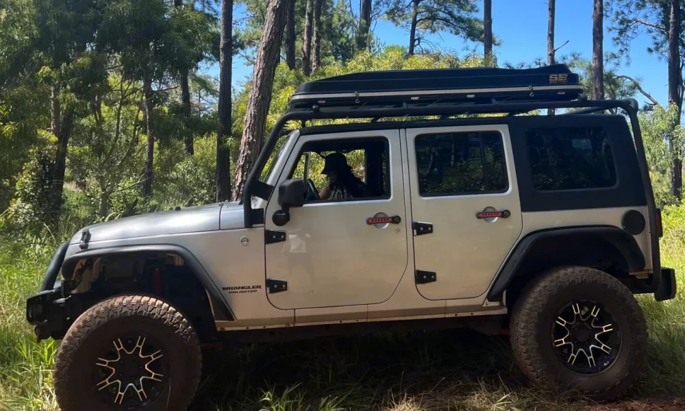 Silver Jeep Wrangler truck camper in Lihue, Hawaii. This 15-foot camper sleeps 2 people in a full-size bed, seats up to 5 guests, has a 4.6-star rating from 15 reviews, offers delivery within 5 miles, includes unlimited mileage, and is not pet-friendly.