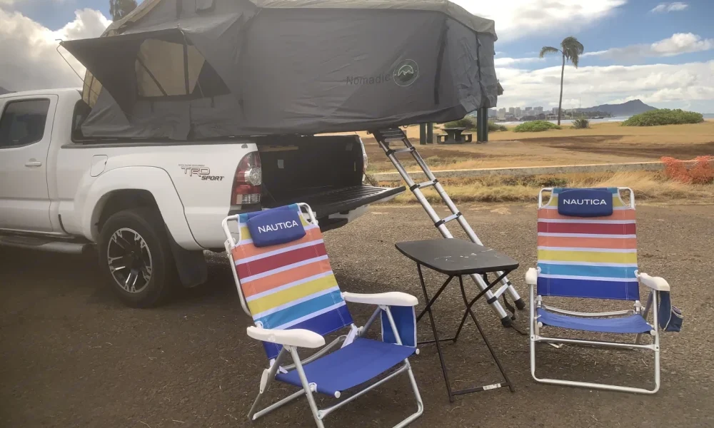 Toyota Tacoma truck camper with a rooftop tent near Honolulu Airport in Honolulu, Hawaii. This 18.4-foot camper sleeps 2 guests, has a 5.0-star rating from 12 trips, does not have a generator, and is not pet-friendly.