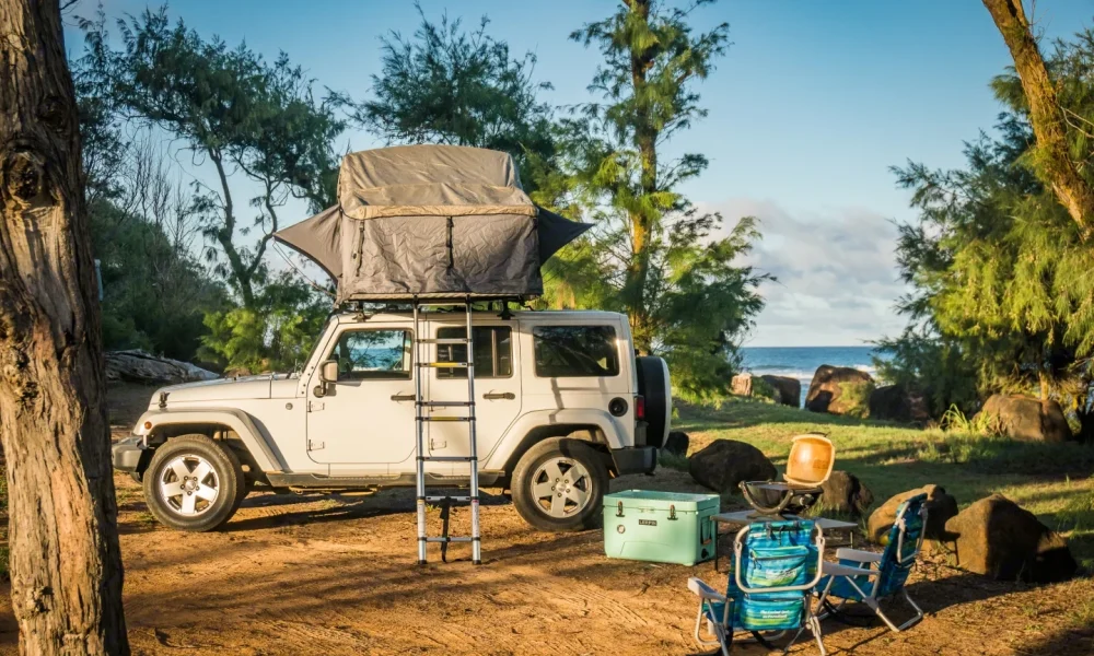 White Wrangler Kauai camper Jeep in Lihue, Hawaii. This 18-foot camper sleeps 2 guests, accommodates up to 4 passengers, has a 4.3-star rating from 23 reviews, offers unlimited mileage, and is not pet-friendly.